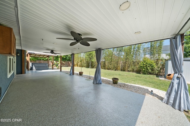 view of patio featuring a ceiling fan, a hot tub, and fence