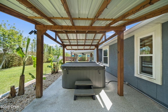 view of patio featuring a ceiling fan, a hot tub, and a fenced backyard