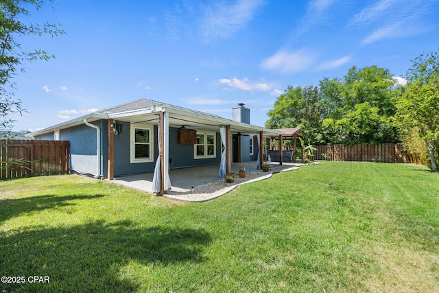 rear view of house with a fenced backyard, a patio, a chimney, and a lawn