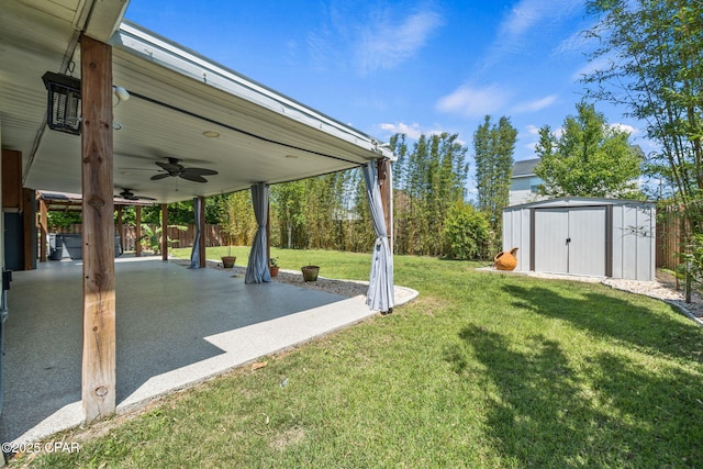 view of yard featuring a ceiling fan, a storage shed, an outbuilding, a patio area, and fence
