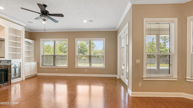 1222 Huntington Ridge Rd, Lynn Haven, FL 32444 - unfurnished living room with crown molding, a glass covered fireplace, wood finished floors, baseboards, and ceiling fan