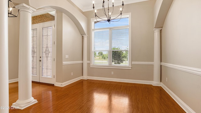 1222 Huntington Ridge Rd, Lynn Haven, FL 32444 - unfurnished dining area featuring an inviting chandelier, crown molding, decorative columns, wood finished floors, and arched walkways