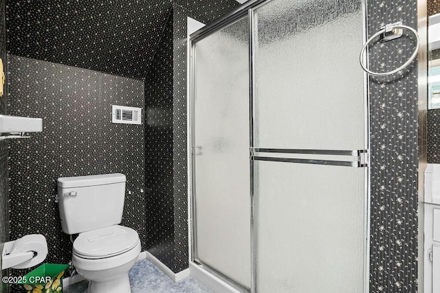 bathroom featuring a stall shower, toilet, and visible vents