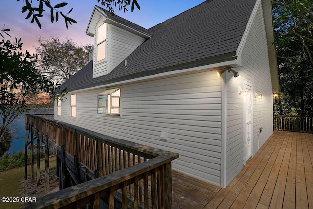 exterior space featuring roof with shingles and a deck