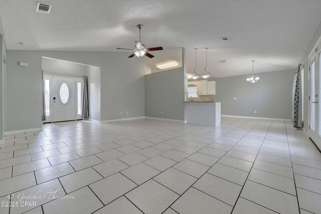 unfurnished living room with baseboards, visible vents, vaulted ceiling, and ceiling fan with notable chandelier