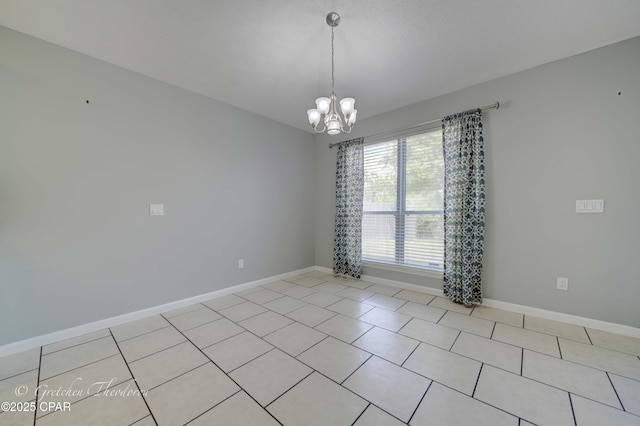 spare room with an inviting chandelier, baseboards, and light tile patterned flooring