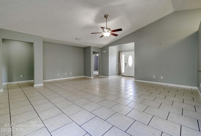 4704 Shannon Ln, Panama City, FL 32404 - unfurnished living room with ceiling fan, a textured ceiling, baseboards, light tile patterned floors, and vaulted ceiling