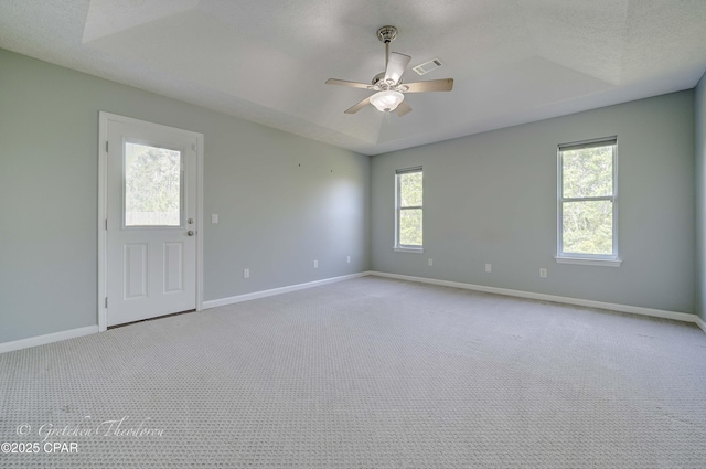 carpeted empty room featuring ceiling fan, visible vents, and baseboards
