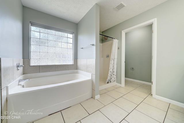 full bathroom with a textured ceiling, a bath, visible vents, tile patterned flooring, and a shower stall