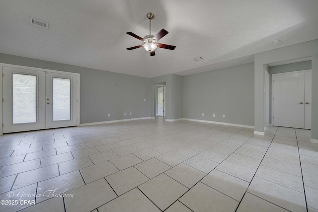 interior space featuring light tile patterned flooring, french doors, a ceiling fan, baseboards, and visible vents