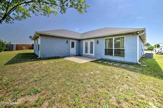 rear view of property with a lawn, fence, french doors, and cooling unit