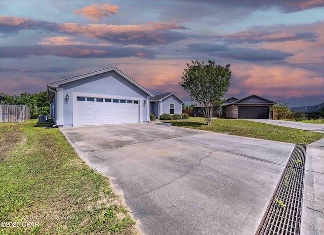 single story home featuring concrete driveway, a lawn, fence, and a garage