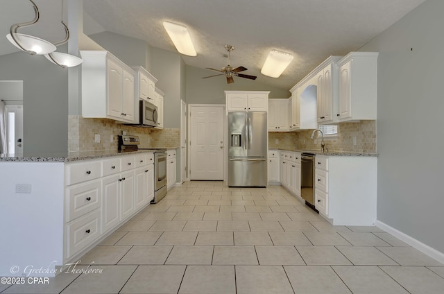 kitchen with lofted ceiling, light stone countertops, tasteful backsplash, a ceiling fan, and stainless steel appliances