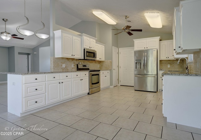 kitchen featuring lofted ceiling, light stone countertops, a ceiling fan, backsplash, and stainless steel appliances