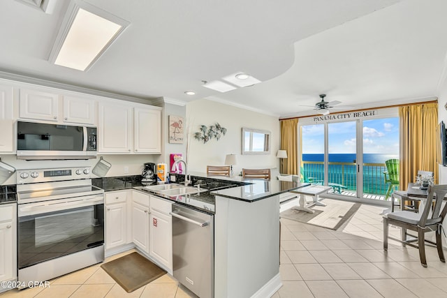 kitchen featuring crown molding, a sink, stainless steel appliances, a peninsula, and light tile patterned floors