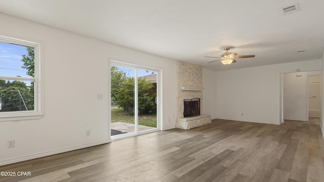 325 Bell Cir, Lynn Haven, FL 32444 - unfurnished living room featuring wood finished floors, ceiling fan, a stone fireplace, and baseboards