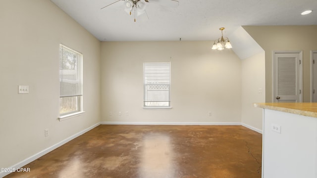 interior space with ceiling fan with notable chandelier, baseboards, and concrete flooring