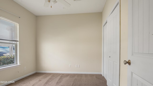 unfurnished bedroom with a ceiling fan, baseboards, light carpet, and a closet