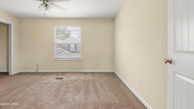 unfurnished room featuring carpet floors, a ceiling fan, a textured ceiling, and visible vents