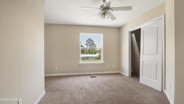unfurnished bedroom with baseboards, a ceiling fan, carpet, and a closet