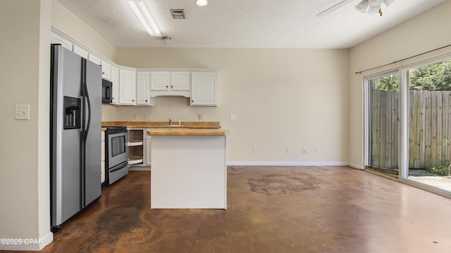 kitchen with a kitchen island, stainless steel appliances, concrete flooring, and white cabinetry