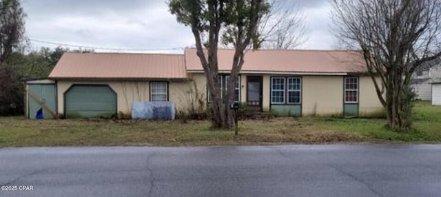 ranch-style house with a garage and stucco siding