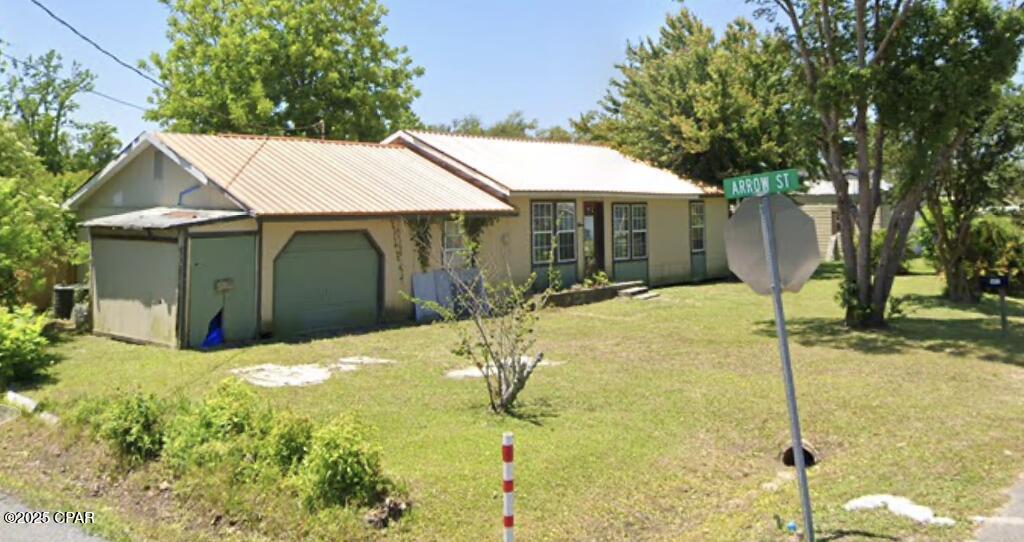 ranch-style home with an attached garage and a front lawn
