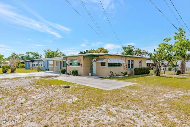 ranch-style house with driveway and a front yard