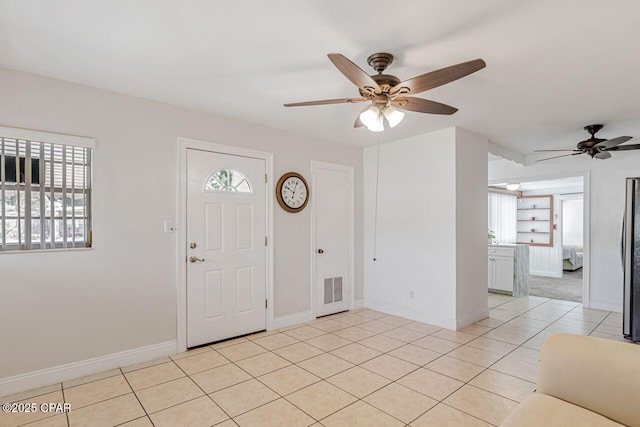 entryway with baseboards, plenty of natural light, a ceiling fan, and visible vents