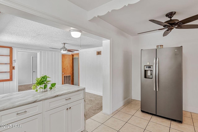 kitchen with white cabinets, ceiling fan, light countertops, baseboards, and stainless steel refrigerator with ice dispenser