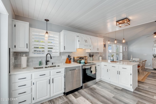 135 Bid A Wee Ln, Panama City Beach, FL 32413 - kitchen featuring stainless steel appliances, a sink, a peninsula, white cabinets, and light countertops