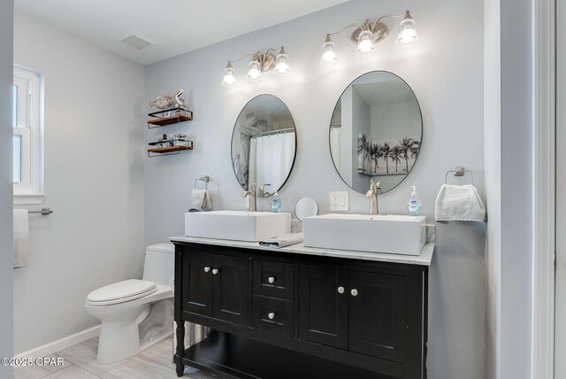 135 Bid A Wee Ln, Panama City Beach, FL 32413 - full bathroom with toilet, double vanity, and baseboards