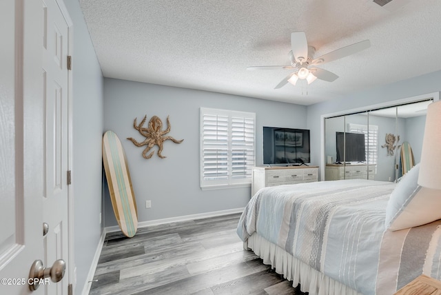 135 Bid A Wee Ln, Panama City Beach, FL 32413 - bedroom with wood finished floors, multiple windows, a textured ceiling, baseboards, and a ceiling fan