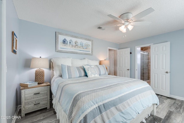 135 Bid A Wee Ln, Panama City Beach, FL 32413 - bedroom with wood finished floors, baseboards, a textured ceiling, connected bathroom, and ceiling fan