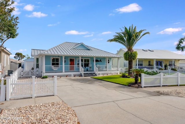135 Bid A Wee Ln, Panama City Beach, FL 32413 - view of front of home with a porch, a standing seam roof, metal roof, and a fenced front yard