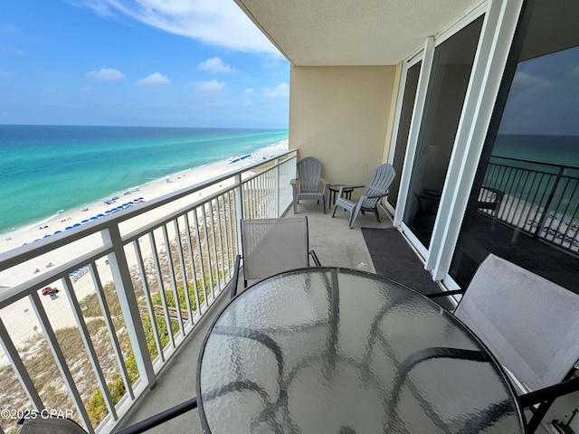 balcony featuring a view of the beach and a water view