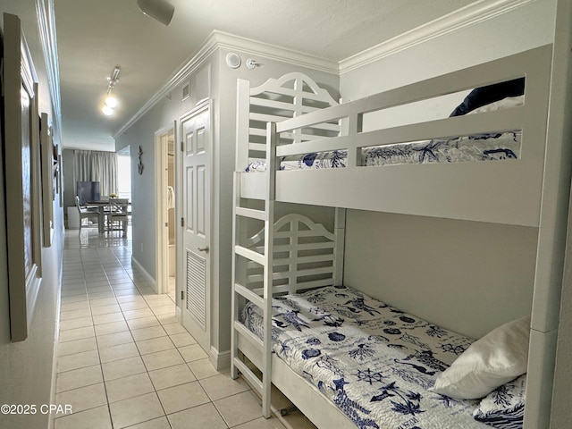 bedroom with crown molding and tile patterned flooring