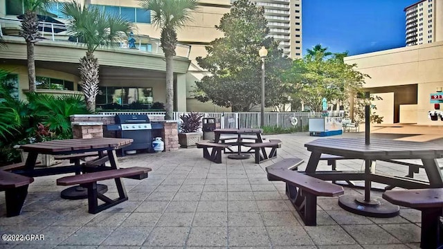 view of property's community with fence, outdoor dining area, and a patio area