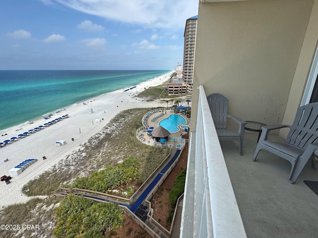 balcony with a water view and a beach view