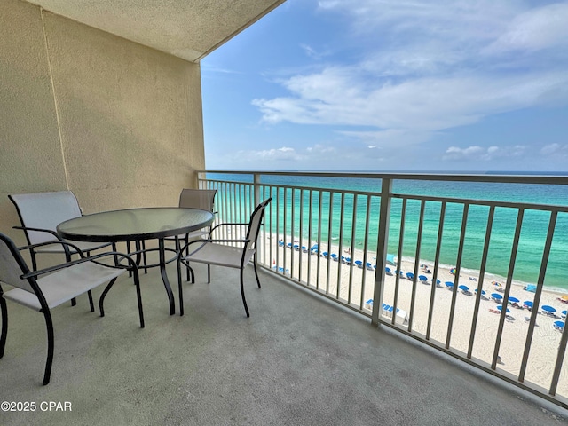 balcony featuring a view of the beach and a water view