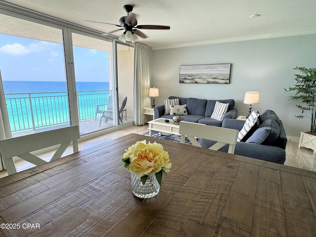 living room with a water view, ornamental molding, ceiling fan, and wood finished floors