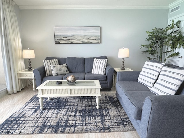 living area featuring ornamental molding, wood finished floors, and visible vents