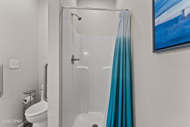 bathroom featuring a stall shower and toilet