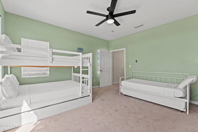 carpeted bedroom featuring baseboards, a ceiling fan, and visible vents