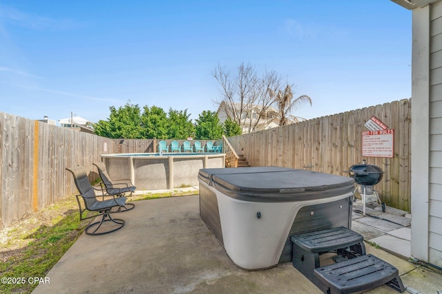 view of patio / terrace with a fenced backyard, a fenced in pool, a hot tub, and grilling area