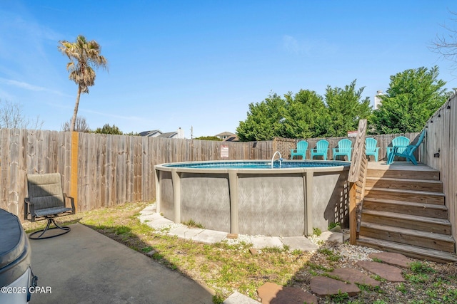 view of pool with a fenced in pool, a fenced backyard, and a wooden deck