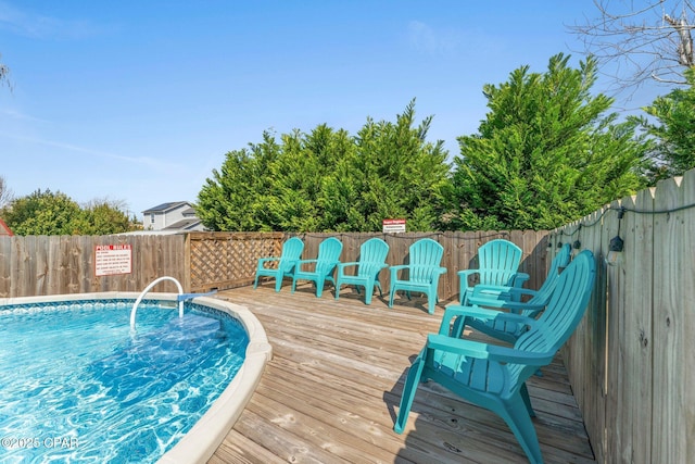 view of pool featuring a fenced backyard and a deck