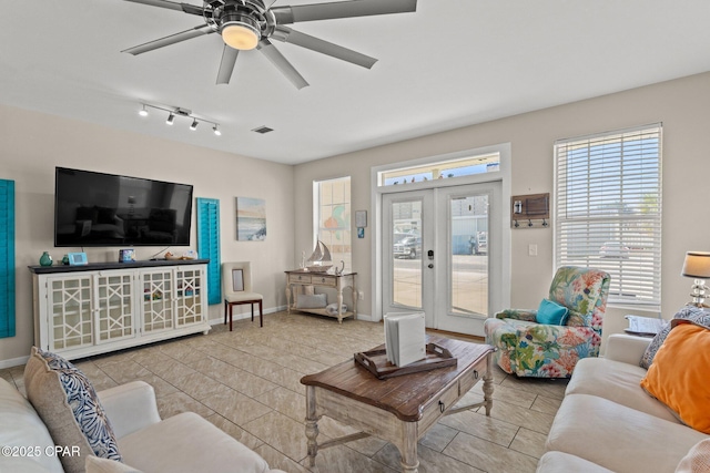 living room with a ceiling fan, tile patterned floors, and a wealth of natural light