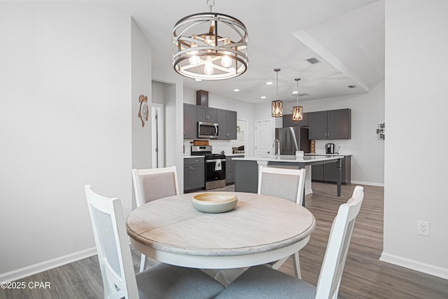 dining space featuring an inviting chandelier, dark wood finished floors, baseboards, and visible vents