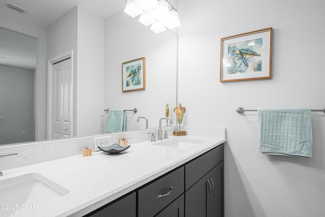 bathroom featuring double vanity, visible vents, and a sink